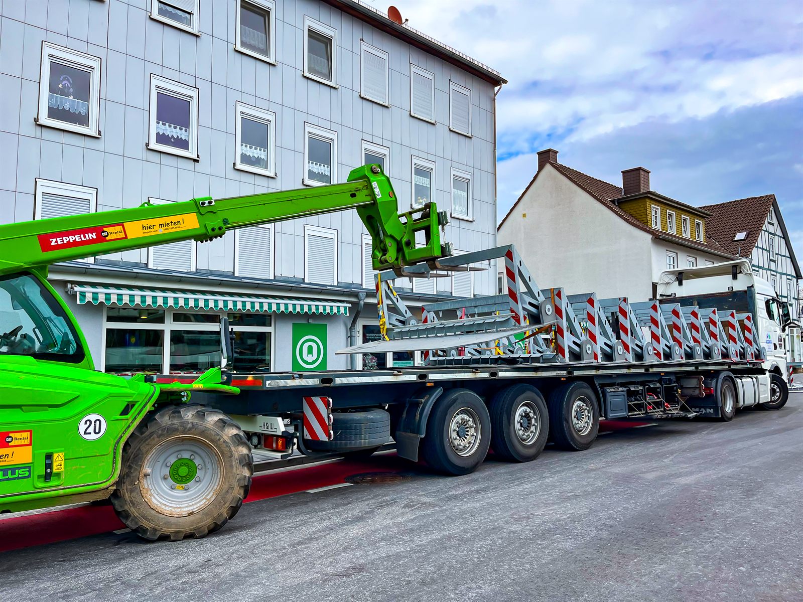 Anlieferung mobiler Fahrzeugsperren mit Sattelzug und Teleskoplader vor einer Veranstaltung