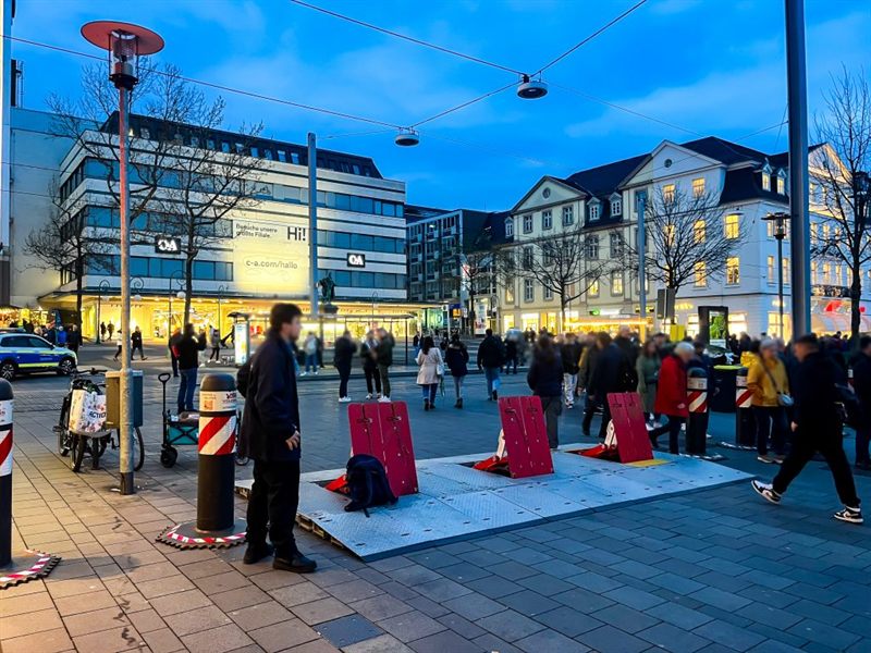 Mobile Fahrzeugsperren an der Zufahrt zu einem Weihnachtsmarkt in der Dämmerung